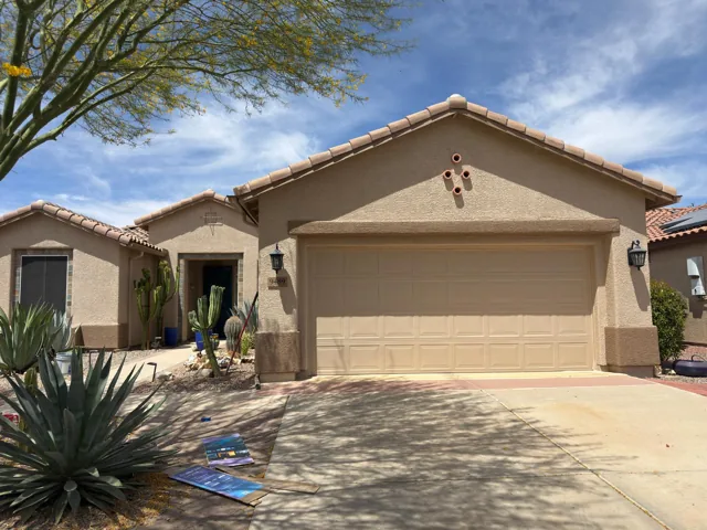 Warm beige house exterior with contrasting trim and a two-car garage